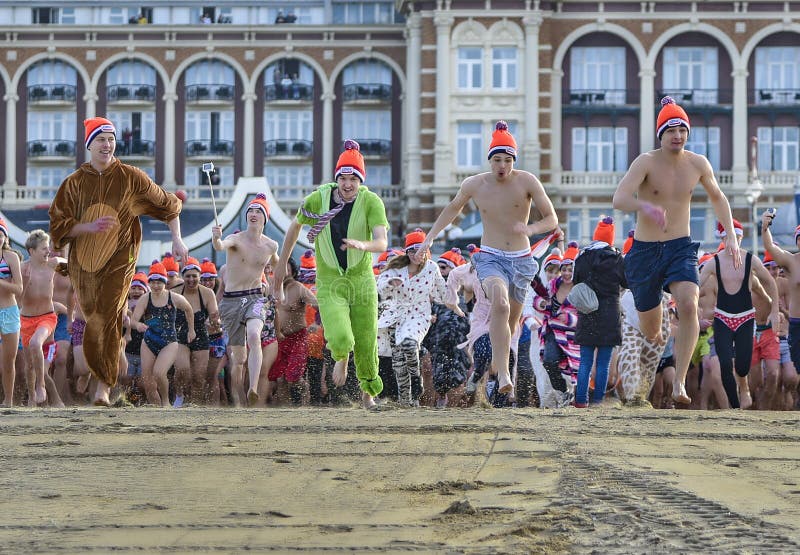 SCHEVENINGEN, 1 January 2018 - Dutch people following the strong tradition of the first new year dive run toward the frozen North Sea water after the midday ring bells on The Hague beach. SCHEVENINGEN, 1 January 2018 - Dutch people following the strong tradition of the first new year dive run toward the frozen North Sea water after the midday ring bells on The Hague beach