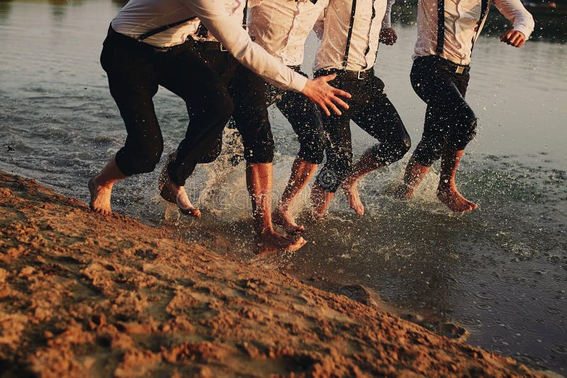 Pies del ` s de los hombres en el agua Se est?n divirtiendo, est?n jugando y est?n salpicando el agua alrededor de ellos Verano imágenes de archivo libres de regalías Pies del ` s de los hombres en el agua Se est?n divirtiendo, est?n jugando y est?n salpicando el agua alrededor de ellos Verano imágenes de archivo libres de regalías