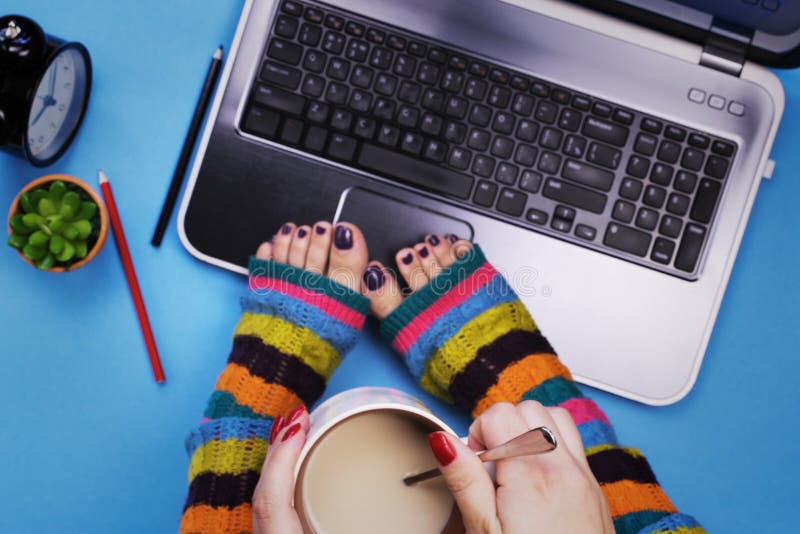 Female feet in socks on the computer. The concept of a woman and a computer. Female feet in socks on the computer. The concept of a woman and a computer.
