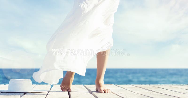 Pies hermosos y sanos de una chica joven en el vestido blanco en un w imagenes de archivo Pies hermosos y sanos de una chica joven en el vestido blanco en un w imagenes de archivo