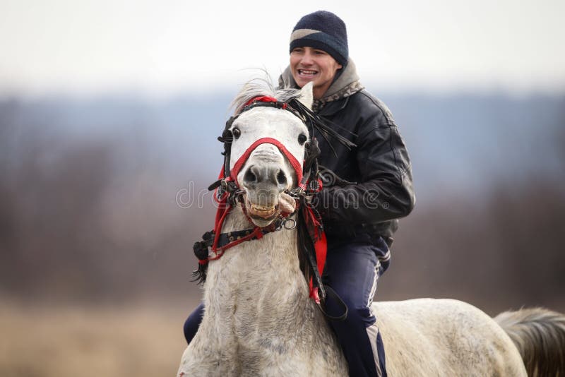 Man is bareback riding an adorned horse before an Epiphany celebration horse race