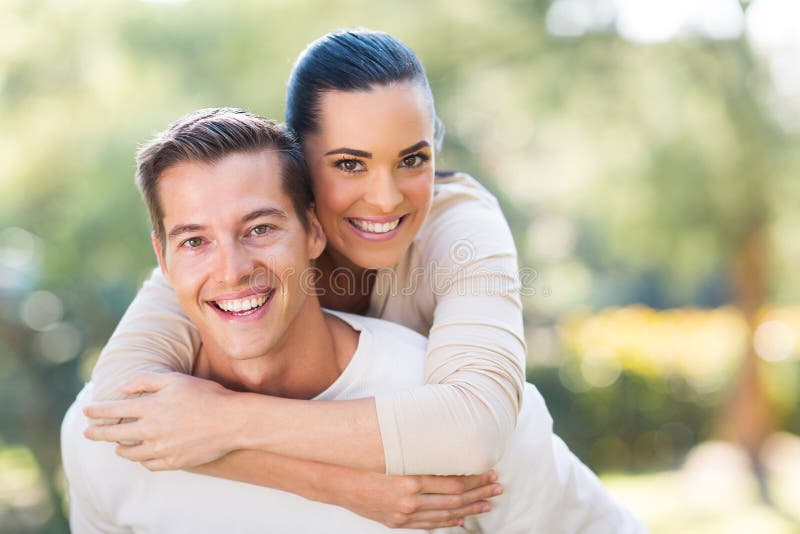 Attractive young couple piggybacking outdoors. Attractive young couple piggybacking outdoors