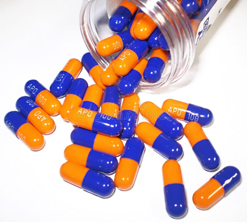 Orange and Blue pills spilling out of bottle on white. Orange and Blue pills spilling out of bottle on white