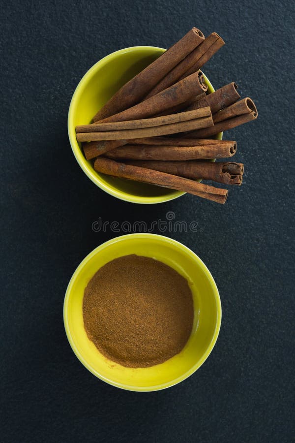 Pijpjes kaneel en poeder in een kom stock foto Pijpjes kaneel en poeder in een kom stock foto