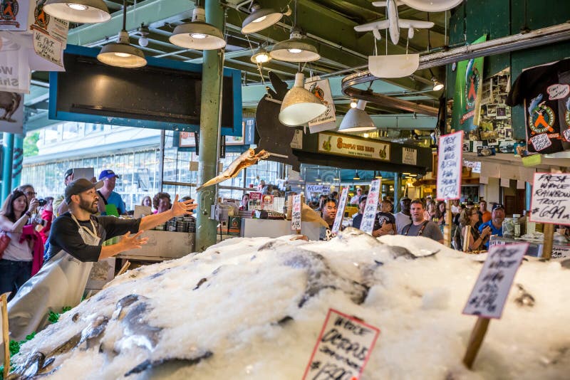 SEATTLE JULY 5: Customers at Pike Place Fish Company wait to order fish at the famous seafood market on July 5, 2014. This market, opened in 1930, is known for their open air fish market style.