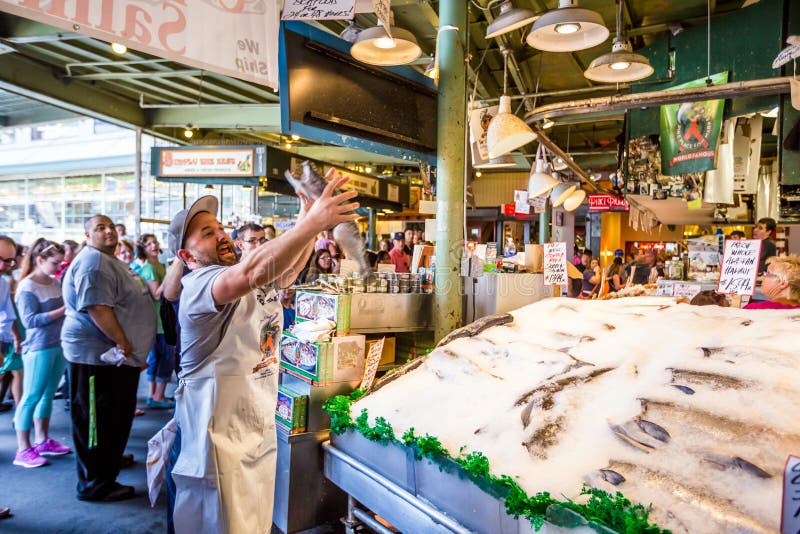 SEATTLE JULY 5: Customers at Pike Place Fish Company wait to order fish at the famous seafood market on July 5, 2014. This market, opened in 1930, is known for their open air fish market style.