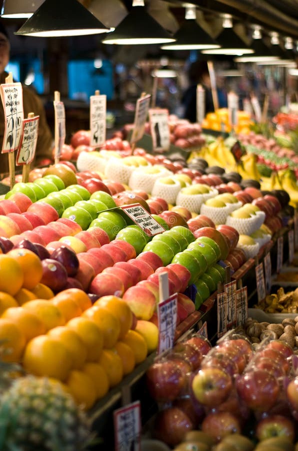 Shoppers buying fruits and vegetables at the famous Pike Place Market in Seattle. Short depth of field.