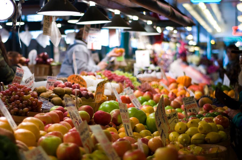 Shoppers buying fruits and vegetables at the famous Pike Place Market in Seattle. Short depth of field.