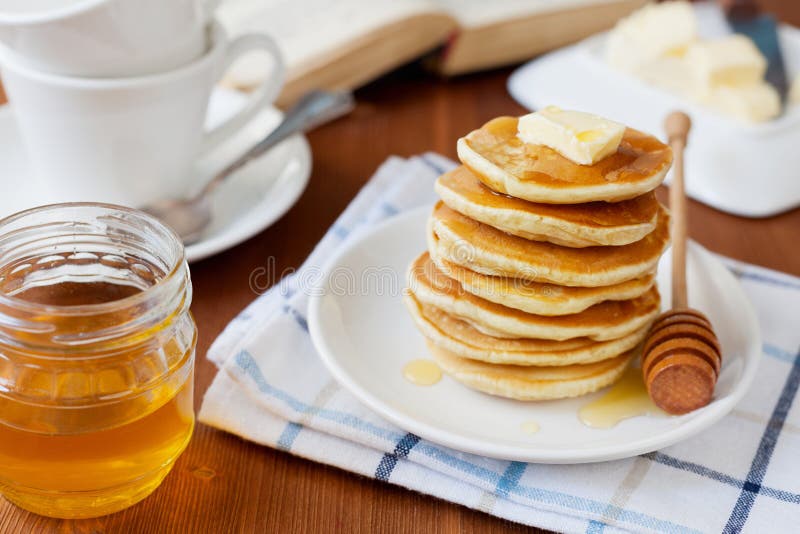 Pila de crepes con el jarabe, la mantequilla y la fresa de la miel en una placa blanca fotos de archivo Pila de crepes con el jarabe, la mantequilla y la fresa de la miel en una placa blanca fotos de archivo