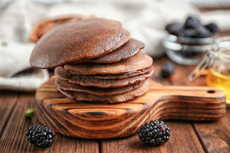 Pila de crepes deliciosas del chocolate en el tablero de madera foto de archivo libre de regalías Pila de crepes deliciosas del chocolate en el tablero de madera foto de archivo libre de regalías