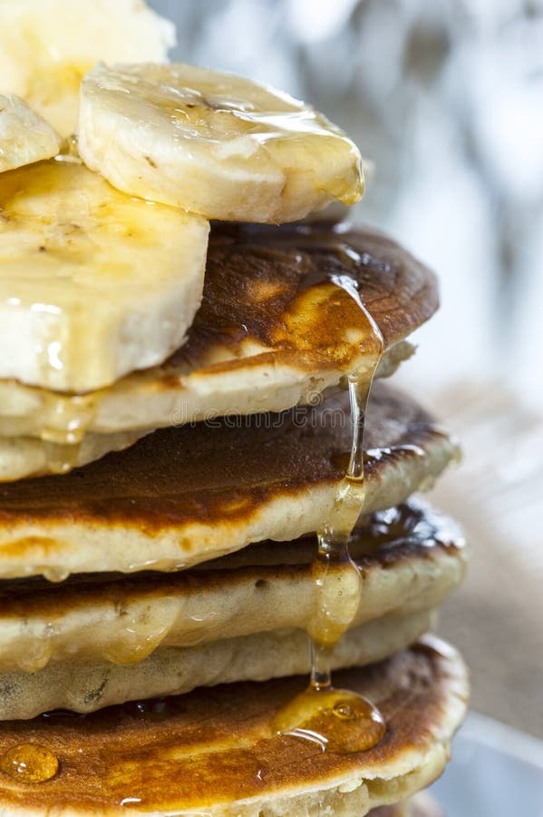 Pila de crepes hechas en casa con las rebanadas y la miel, cierre del plátano para arriba fotos de archivo libres de regalías Pila de crepes hechas en casa con las rebanadas y la miel, cierre del plátano para arriba fotos de archivo libres de regalías