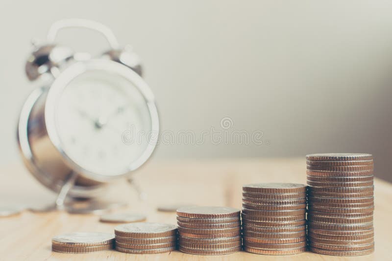 Pila de monedas colocadas en las escaleras en el tablero de madera con el reloj, Fina foto de archivo Pila de monedas colocadas en las escaleras en el tablero de madera con el reloj, Fina foto de archivo
