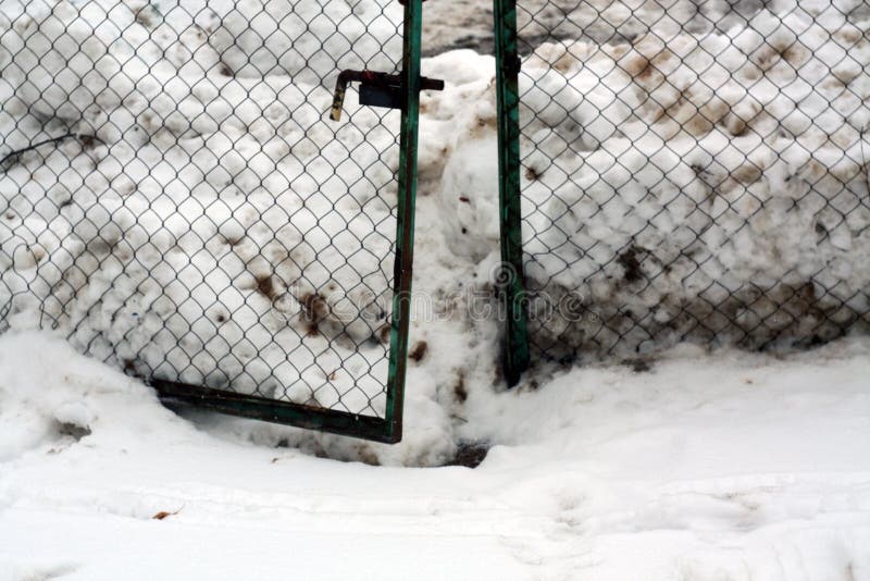 Pila de nieve y de vieja puerta del metal imagenes de archivo Pila de nieve y de vieja puerta del metal imagenes de archivo