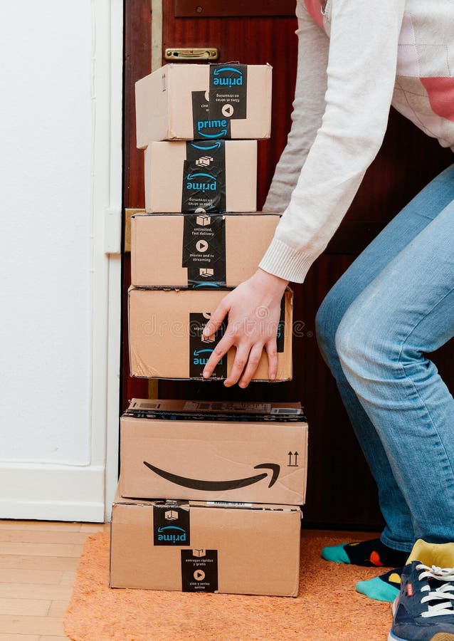 Pila de paquetes de la prima del Amazonas entregados a una mujer casera de la puerta imagenes de archivo Pila de paquetes de la prima del Amazonas entregados a una mujer casera de la puerta imagenes de archivo