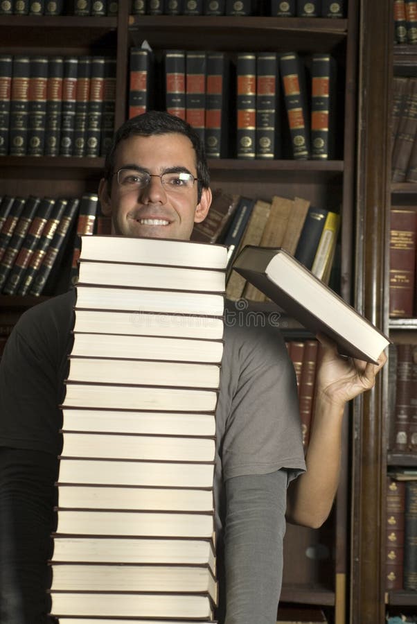 Pila del asimiento de los pares de libros en la biblioteca - vertical foto de archivo Pila del asimiento de los pares de libros en la biblioteca - vertical foto de archivo
