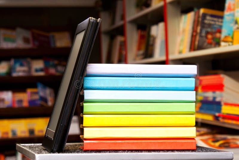 Pila di libri variopinti con il lettore del e-libro fotografia stock libera da diritti Pila di libri variopinti con il lettore del e-libro fotografia stock libera da diritti