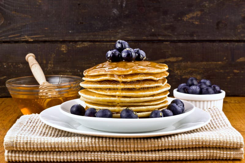 Pila di pancake con il mirtillo ed il miele freschi immagine stock libera da diritti