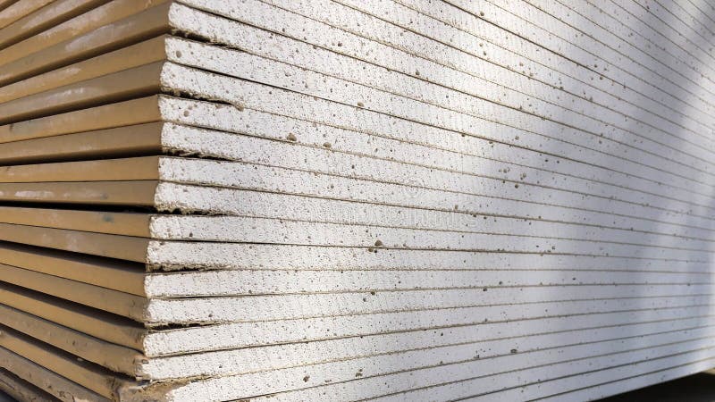 Piled sheets of drywall at the construction site. Stacked plasterboard sheets. Gypsum cardboard. Piled sheets of drywall at the construction site. Stacked plasterboard sheets. Gypsum cardboard.