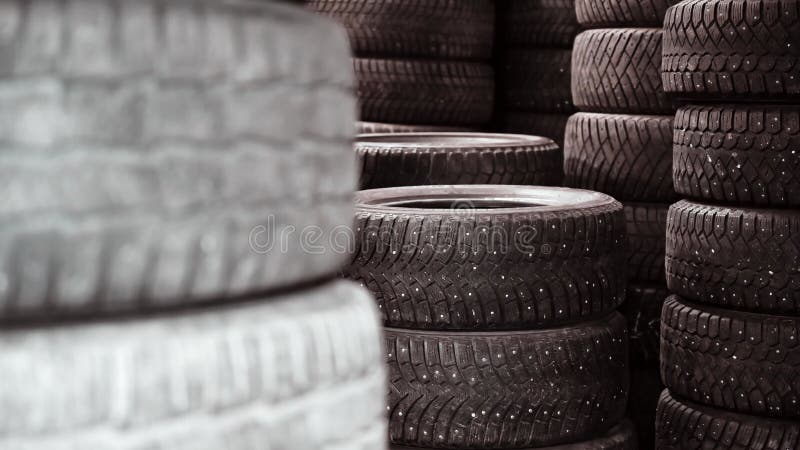 Pilas de neumáticos usados almacenados en un almacén. un montón de neumáticos para reciclado metrajes