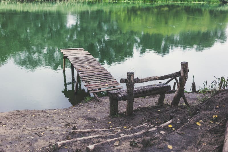 Pilastro su un fiume calmo di estate Ponte di legno del pilastro fotografia stock Pilastro su un fiume calmo di estate Ponte di legno del pilastro fotografia stock