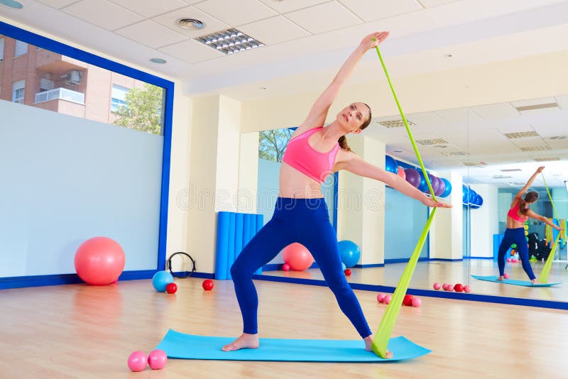 Pilates woman standing rubber band exercise workout at gym indoor. Pilates woman standing rubber band exercise workout at gym indoor