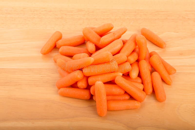 Pile of Baby Carrots on Wood Table royalty free stock photo