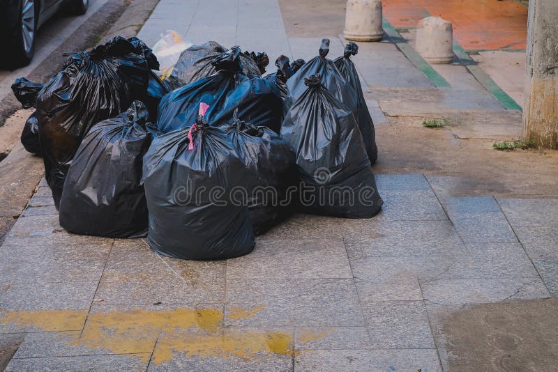 Big pile of black plastic garbage bags with trash stacked on the street trash  bags. on the street at utility workers strike day Stock Photo - Alamy