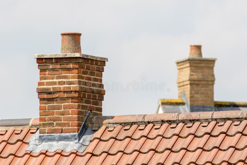 Pile de cheminée de brique sur le dessus contemporain moderne de toit de maison photographie stock Pile de cheminée de brique sur le dessus contemporain moderne de toit de maison photographie stock
