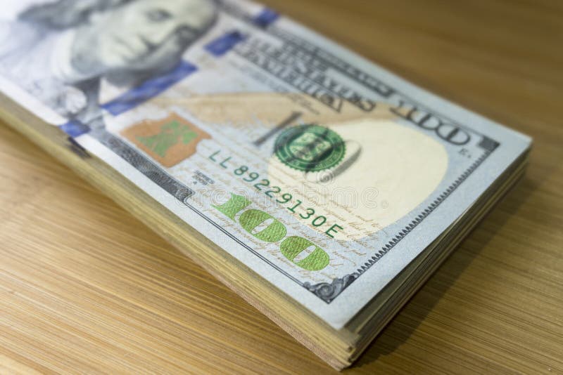 Pile de Crolled de 100 nouveaux billets d'un dollar sur le fond en bois photographie stock libre de droits Pile de Crolled de 100 nouveaux billets d'un dollar sur le fond en bois photographie stock libre de droits
