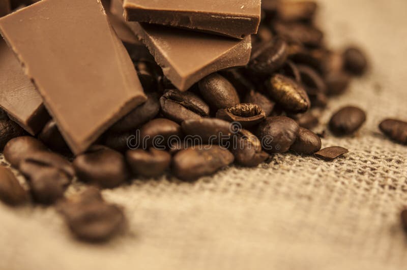 Pile de fèves de café avec chocolat sur fond de tissu burlap