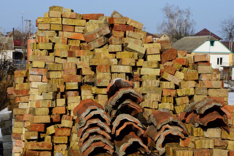 Pile de vieilles briques et tuiles de toit brunes sur une rue rurale images stock Pile de vieilles briques et tuiles de toit brunes sur une rue rurale images stock