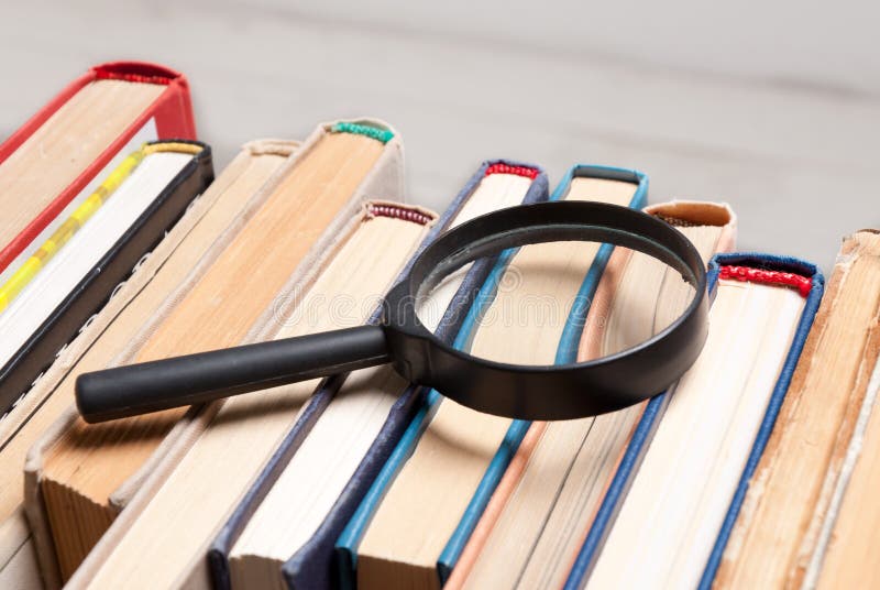 Pile de vieux livres de livre cartonné avec la loupe Recherchez l'information appropriée et nécessaire dans un grand nombre de du image libre de droits Pile de vieux livres de livre cartonné avec la loupe Recherchez l'information appropriée et nécessaire dans un grand nombre de du image libre de droits