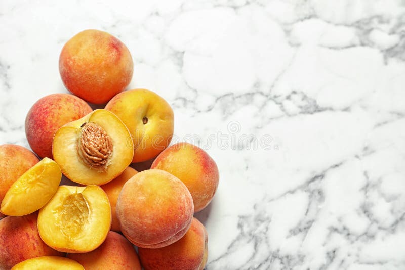 Pile of delicious ripe peaches on marble background