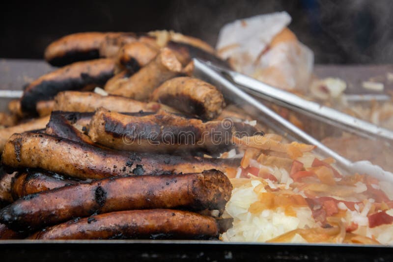 Pile des saucisses et des hot dogs sur un gril chaud qui fume photos libres de droits Pile des saucisses et des hot dogs sur un gril chaud qui fume photos libres de droits