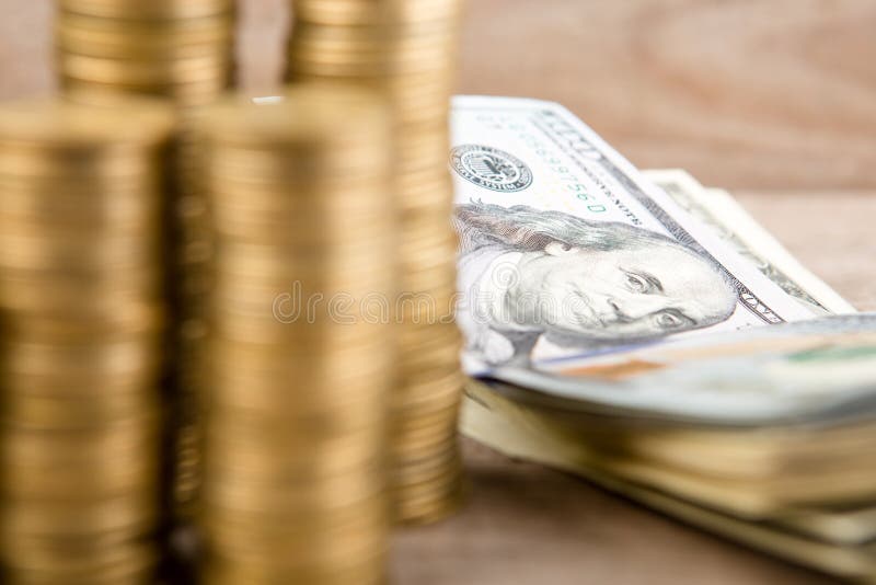 Pile di monete e di banconote in dollari immagini stock Pile di monete e di banconote in dollari immagini stock