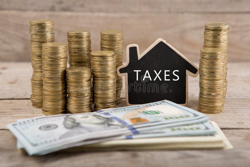 Pile di monete e di banconote in dollari, lavagna con testo & x22; TAXES& x22; fotografie stock libere da diritti Pile di monete e di banconote in dollari, lavagna con testo & x22; TAXES& x22; fotografie stock libere da diritti