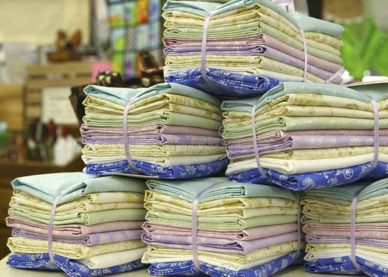 Stacks of fat quarters, quilting fabric, in blues, lavender, greens and yellow bundled for sale. Stacks of fat quarters, quilting fabric, in blues, lavender, greens and yellow bundled for sale