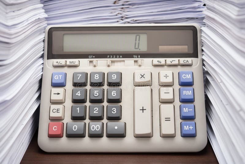 Pile of documents on desk stack up high with calculator stock images Pile of documents on desk stack up high with calculator stock images