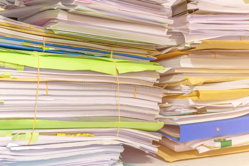 Pile of documents on desk stack up high waiting to be managed. Group, data.