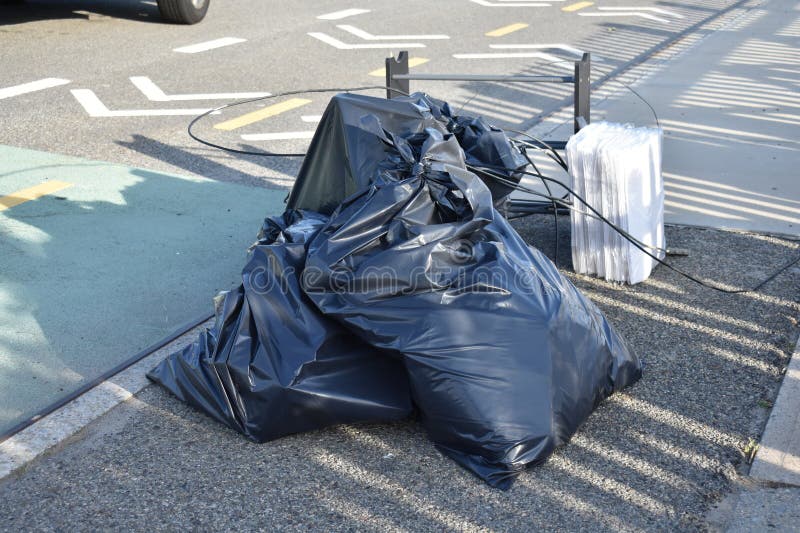 Black Trash Bags Along A Street And Sidewalk In Greenwich Village