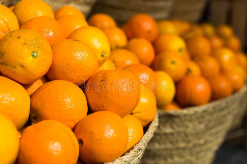 Pile of juicy oranges in wicker baskets on market counter stock images Pile of juicy oranges in wicker baskets on market counter stock images