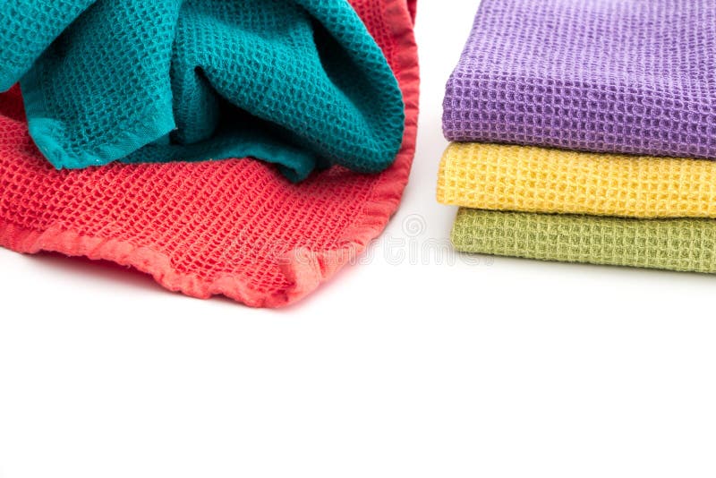 Pile of messy and stack of folded colorful kitchen towels, on white stock image