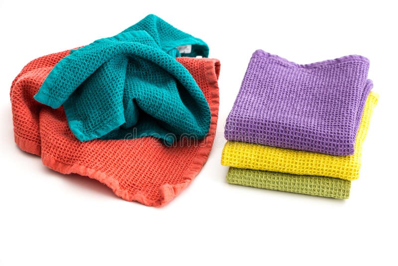 Pile of messy and stack of folded colorful kitchen towels, on white stock image