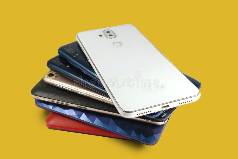 Pile of mobile phones, Back view of smartphone isolated on yellow background stock photo