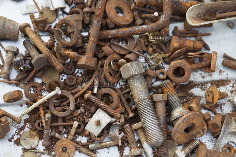 A bunch of old rusty bolts with nuts and washers. metal fasteners covered w...