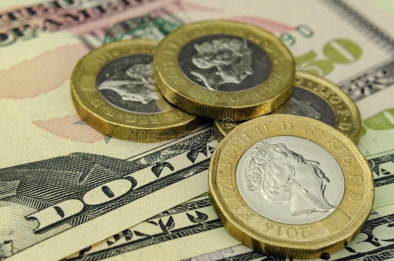 Pile of one pound coins on top of 50 dollar note. Close up photo, with shallow depth of field. Concept for currency exchange