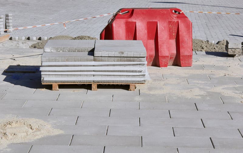 Pile of pavement. Laying gray concrete paving slabs. Construction Site. stock images