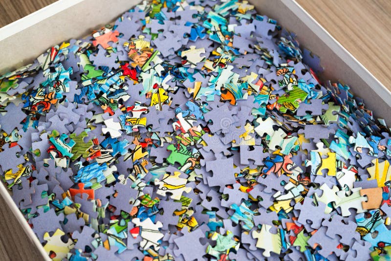 Pile of puzzles in box lies on the table