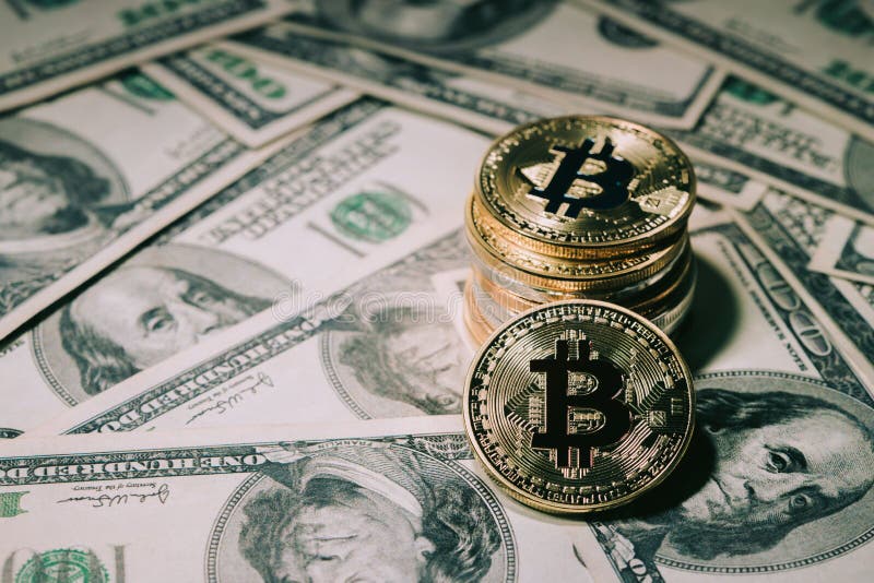 Pile of stacking Golden bitcoin on one hundred dollar banknotes. stock photography
