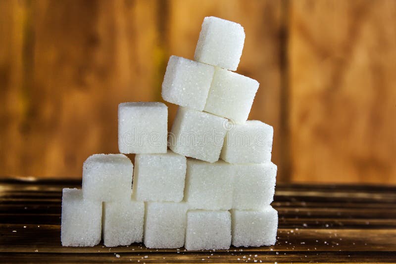 Pile of Sugar Cubes Stacking on Table over Wooden Background. stock photography